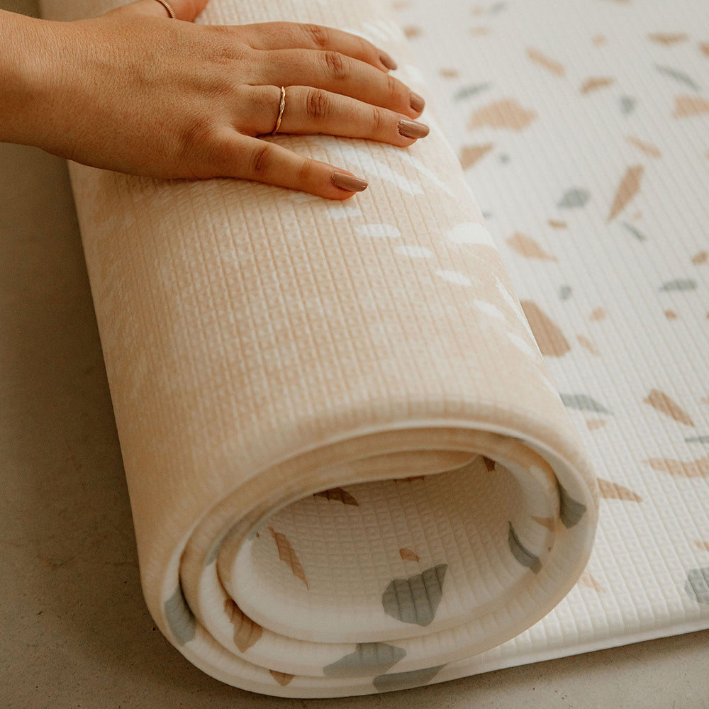 personne en train d'enrouler le tapis de jeu xl le granite