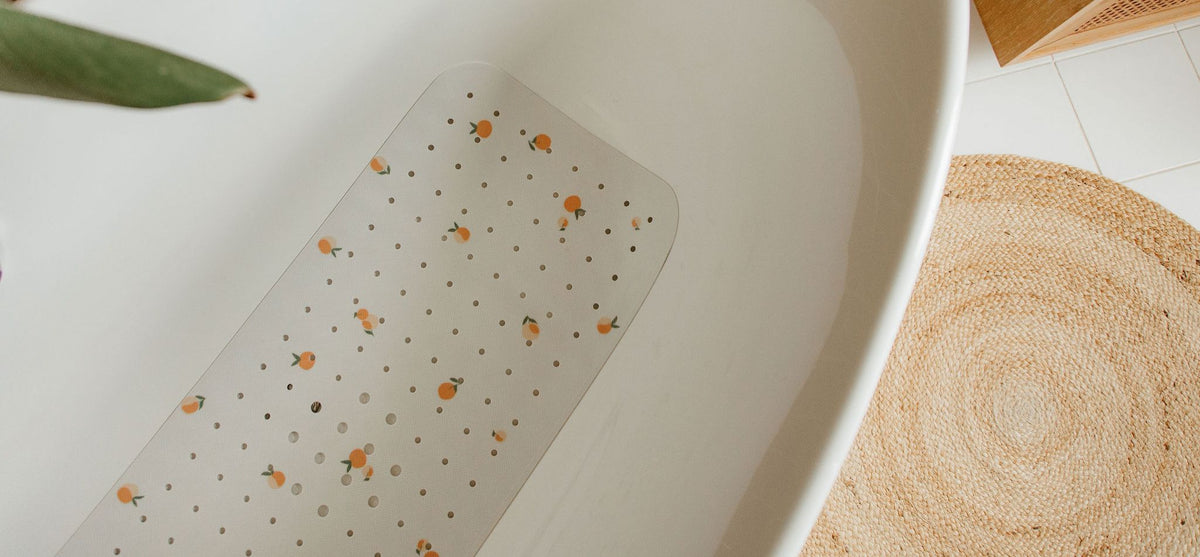 tapis de bain avec des motifs pêchs posé dans une baignoire