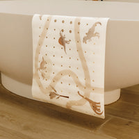 tapis de bain le dino exposé sur la baignoire