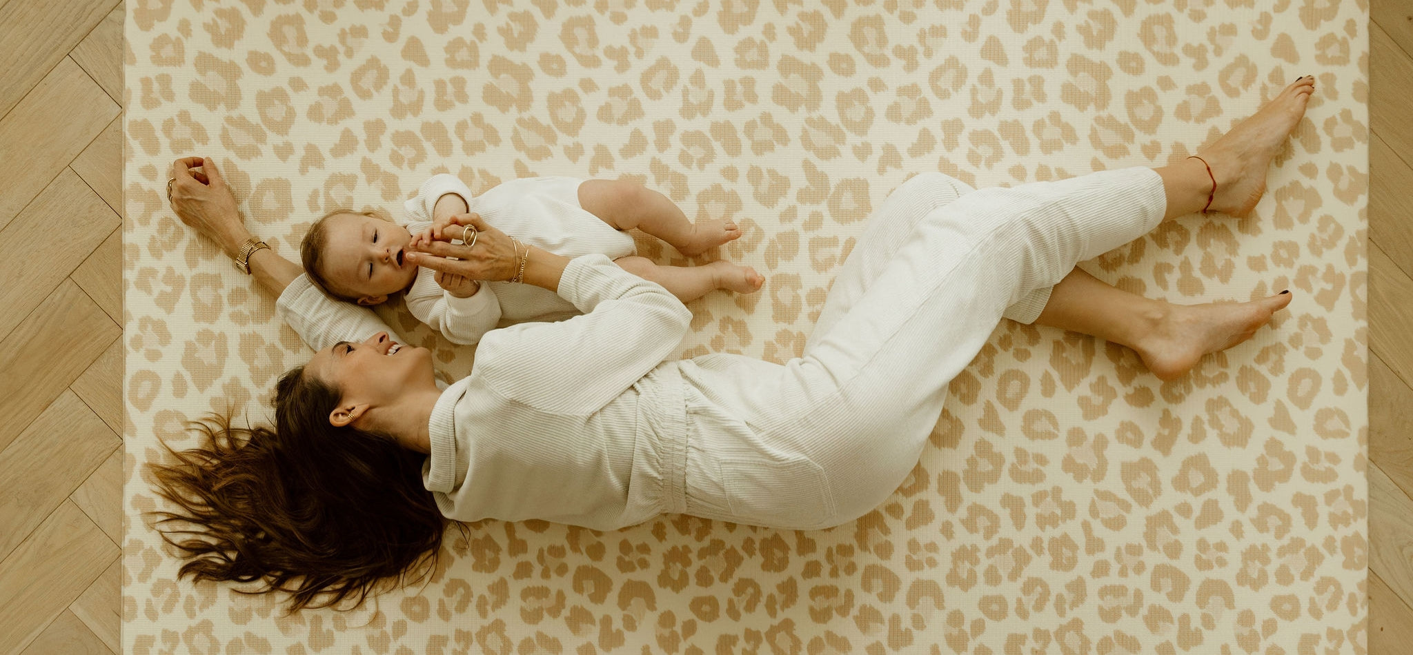 maman avec bébé sur le tapis de jeu XL motif léopard tapilou